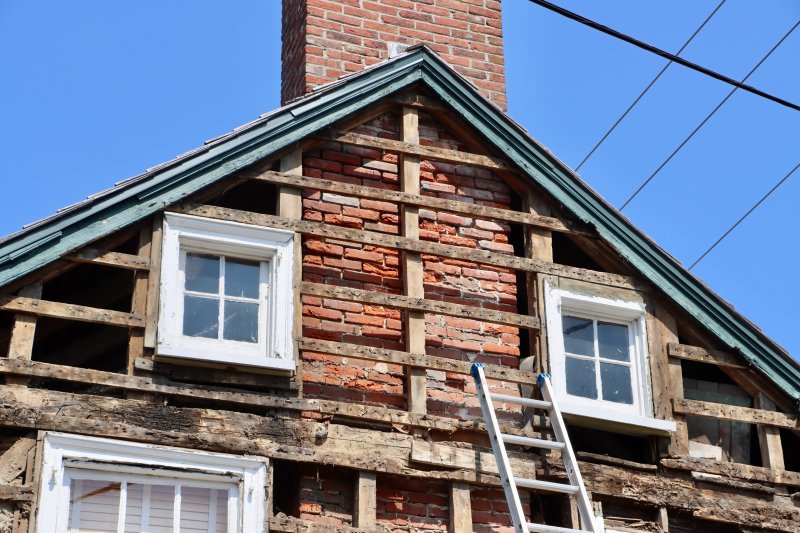 With the old exterior gone, the framing and brick chimney are now exposed.
